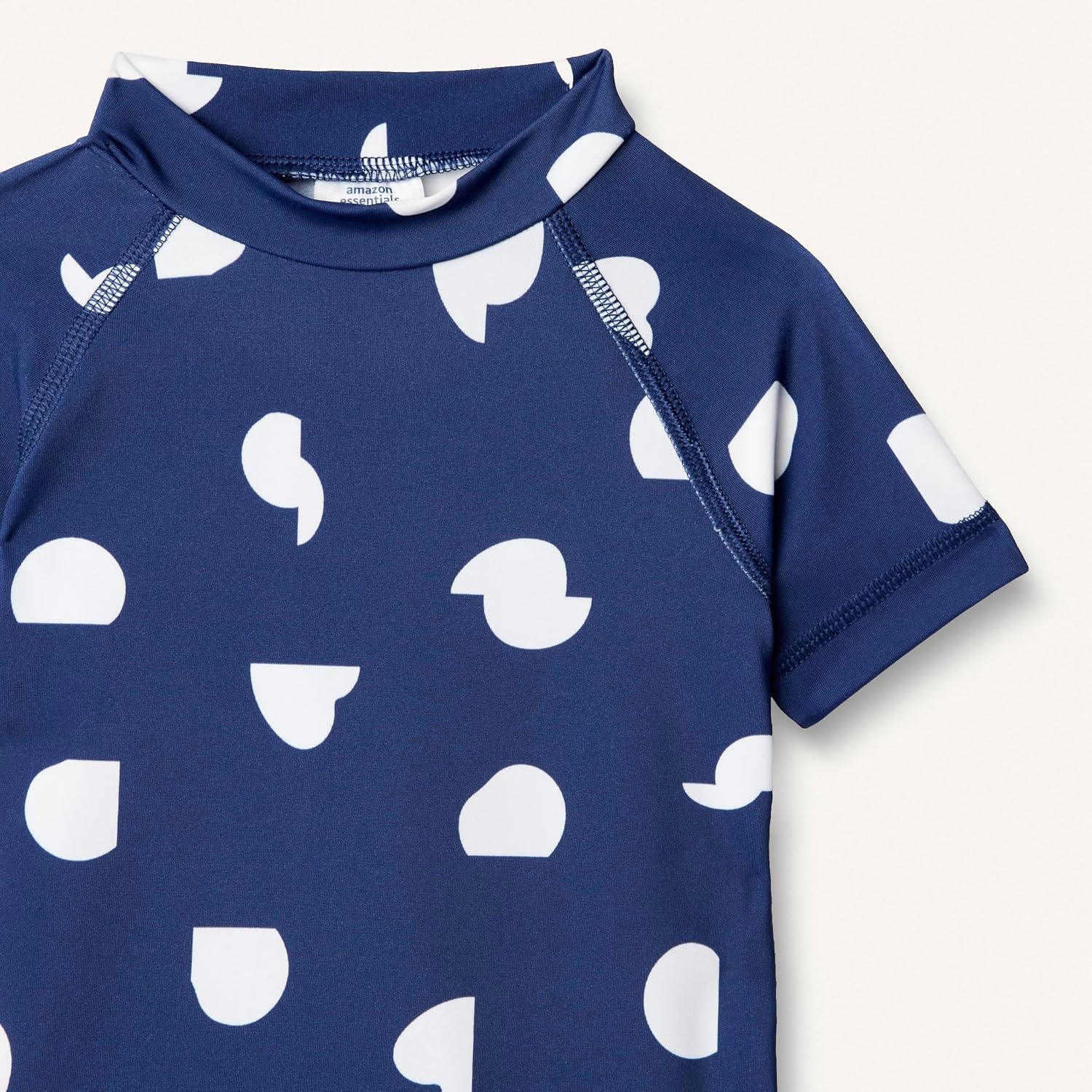 image:imageAmazon Essentials Girls and Toddlers Short Sleeve Slim Fit HighNeck Rashguard TShirtDeep Blue Ivory Abstract Dots
